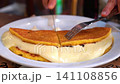 A scene of cutting "cachapa," a sweet corn pancake with melted cheese, a popular Latin American dish. 141108856
