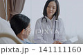 Asian female doctor is talking to a patient in the hospital room, she is reporting an examination. 141111160