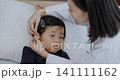 Doctor checking hearing aid, young Asian girl with hearing disorder, doctor treating patient 141111162