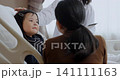 Young Asian female patient is being examined by a doctor in the hospital room, parents are asking the doctor about her symptoms. 141111163