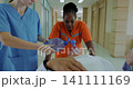 A medical team is urgently moving a patient who has stopped breathing, an emergency patient is performing CPR, a doctor is using an ambu bag. 141111169