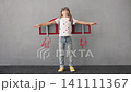 Funny child playing with cardboard craft jetpack 141111367