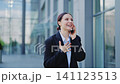 Joyful Professional Woman Chatting on Smartphone Outdoors 141123513