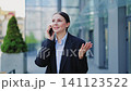 Professional Woman Engaged in Joyful Phone Call Outdoors 141123522