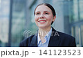 Happy Businesswoman Engaged With Mobile Phone In Urban Setting 141123523