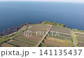 A drone slowly moves forward, capturing the beautiful terraced rice fields of Arai in Ine, Kyoto, with the Sea of Japan as a backdrop. 141135437