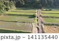 A drone slowly moves forward, capturing the scenery of the "Arai Rice Terraces" in Ine, Kyoto, as the fields descend to the lush green terraced rice paddies at the foot of the mountain. 141135440