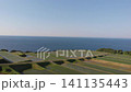 A drone-style aerial shot capturing the beautiful terraced rice fields of Arai in Ine, Kyoto, with the Sea of Japan as a backdrop, as the camera ascends directly overhead. 141135443