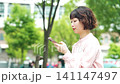 屋外でスマートフォンを使う女性・ビジネスウーマン 141147497