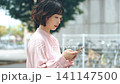 屋外でスマートフォンを使う女性・ビジネスウーマン 141147500