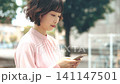 屋外でスマートフォンを使う女性・ビジネスウーマン 141147501