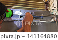 Air Conditioner Cleaning and Maintenance Service Technician Repairing Indoor AC Unit 141164880