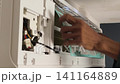 Air Conditioner Cleaning and Maintenance Service Technician Repairing Indoor AC Unit 141164889