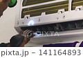 Air Conditioner Cleaning and Maintenance Service Technician Repairing Indoor AC Unit 141164893