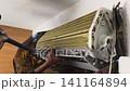 Air Conditioner Cleaning and Maintenance Service Technician Repairing Indoor AC Unit 141164894