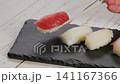 日本の美味しいマグロのお寿司を持ち上げる 141167366