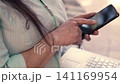 Beautiful mature Latina executive professional, with headphones and her cell phone, working on her laptop and enjoying the day, sitting in a park. Learning, home office 141169954