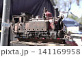 View of a colorful, well-maintained, handcrafted locomotive. For decoration or souvenirs. Made from recyclable materials. In a public place, with natural light. 141169958