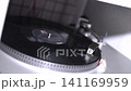 Stereo equipment, vinyl records in good condition, working and spinning. Retro style, with their turntable, colors, needle, and buttons, illuminated in a store and well displayed. 141169959