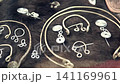 A highly detailed view of medieval ornaments. Featuring antique style, knives, a helmet, Norse symbols, accessories, irons, and a scabbard. Medieval knight's clothing and accessories. 141169961