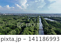 An aerial top-down perspective showcases a lush mangrove forest with clusters of dense green trees surrounded by calm, dark water, highlighting a thriving coastal ecosystem in a tropical region. 141186993