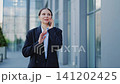 Joyful Businesswoman Conversing on Smartphone 141202425