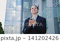 Smiling Professional Engaged With Smartphone Outdoors 141202426