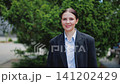 Smiling Professional Woman Standing Outdoors, Confident Expression 141202429