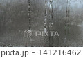 Foggy window glass with condensation forming water droplets and streaks. 141216462