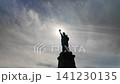 Statue of liberty silhouette against a cloudy sky 141230135