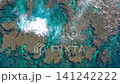 Waves crashing against the rocky shores of emerald-colored coral reefs. 141242222