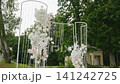 Elegant wedding ceremony floral arch with cascading white and pink flowers 141242725
