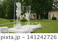 Elegant wedding ceremony decoration with floral arrangements and white backdrop 141242726