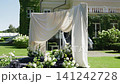 Elegant wedding ceremony decoration with draped fabric and floral arrangements 141242728