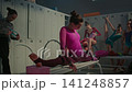 Focused Rhythmic Gymnast Performing Deep Over split Stretching on Bench 141248857