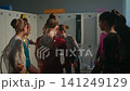 Young Gymnasts Admiring and Discussing Sparkling Leotards in Dressing Room 141249129