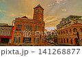 Time lapse Beautiful blue hour cityscape featuring the historic clock tower in Phuket Old Town with illuminated heritage buildings, dynamic traffic, and stormy clouds. 141268877