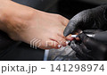 A woman's feet during a pedicure. Woman getting pedicure in beauty salon, closeup. A pedicurist working at a beauty salon. Beauty salon concept: pedicures. A woman's feet during a pedicure. Woman getting pedicure in beauty salon, closeup. A pedicurist working at a beauty salon. Beauty salon concept: pedicures. 141298974