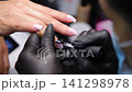 A woman's hand during a manicure. A woman getting a manicure. A manicurist is doing a client's nails at a nail salon. Beauty salon concept: manicures, pedicures. A woman's hand during a manicure. A woman getting a manicure. A manicurist is doing a client's nails at a nail salon. Beauty salon concept: manicures, pedicures. 141298978