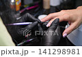 A woman's hand during a manicure. A woman getting a manicure. A manicurist is doing a client's nails at a nail salon. Beauty salon concept: manicures, pedicures. A woman's hand during a manicure. A woman getting a manicure. A manicurist is doing a client's nails at a nail salon. Beauty salon concept: manicures, pedicures. 141298981