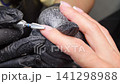 A woman's hand during a manicure. A woman getting a manicure. A manicurist is doing a client's nails at a nail salon. Beauty salon concept: manicures, pedicures. A woman's hand during a manicure. A woman getting a manicure. A manicurist is doing a client's nails at a nail salon. Beauty salon concept: manicures, pedicures. 141298988