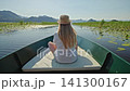 Teenage girl relaxing on a boat trip across Skadar Lake National Park in Montenegro. Peaceful summer journey through pristine wetlands  141300167