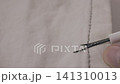 Removing gray thread with seam ripper 141310013