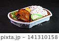 A video of a chicken teriyaki bento box rotating against a black background. 141310158