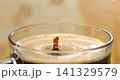 Falling drop into coffee cup creating a splash and ripple in crema, super slow motion 1000 fps 141329579
