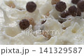 Corn balls breakfast cereal falling into milk or yogurt with splash in super slow motion 1000 fps 141329587