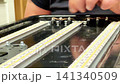Focusing on intricate details, hands skillfully connect tiny components of a model track, showcasing the beauty of craftsmanship and patience throughout 141340509