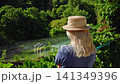 Woman in straw hat overlooking Blue Eye spring in Albania 141349396