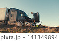 Truck driver inspecting a broken down semi truck engine 141349894