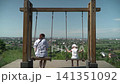 Tourist spot, swing with panoramic view, two girls riding, slow motion, sunny summer day 141351092